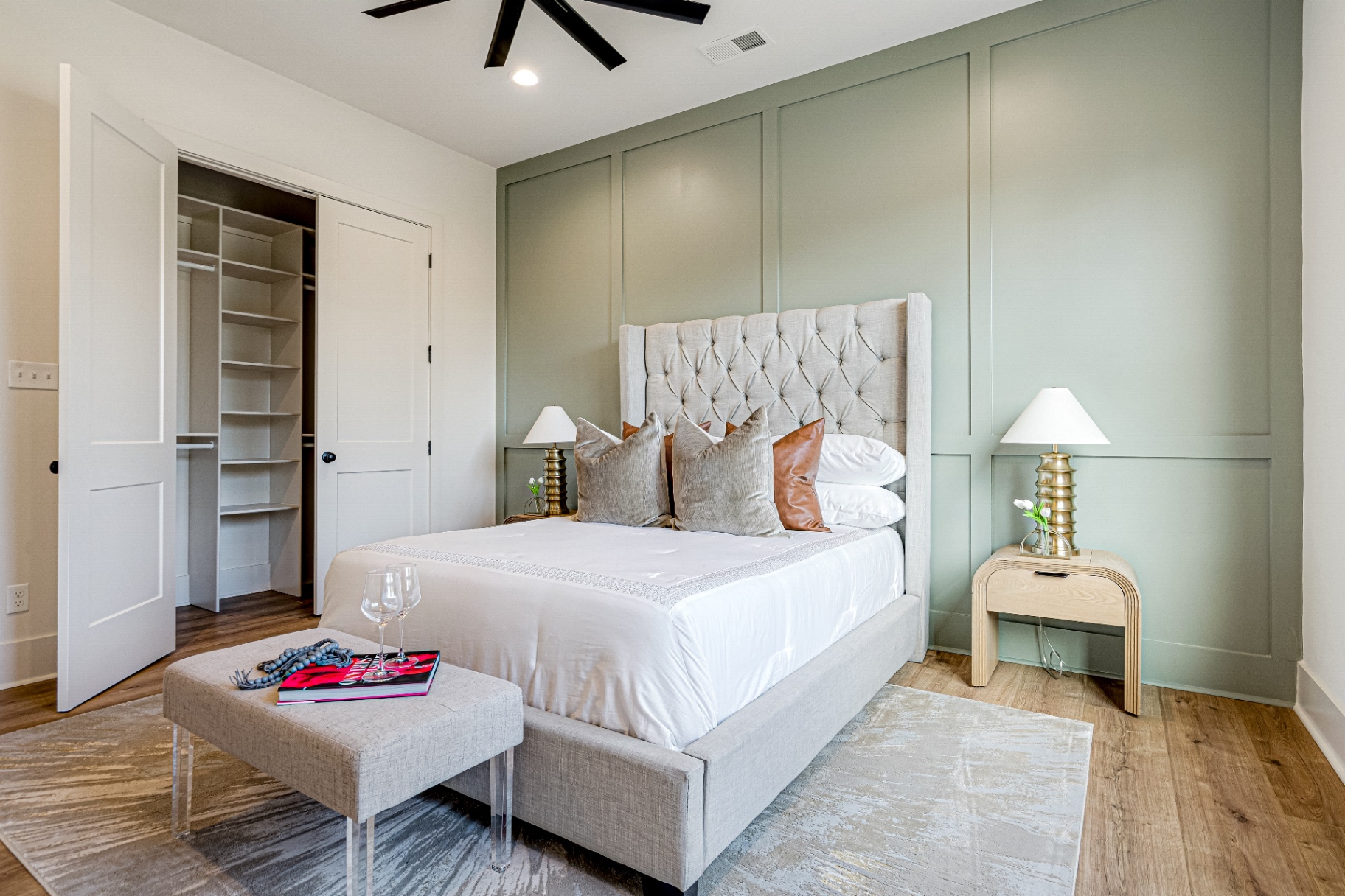 Guest bedroom with sage board-and-batten accent wall and tufted headboard