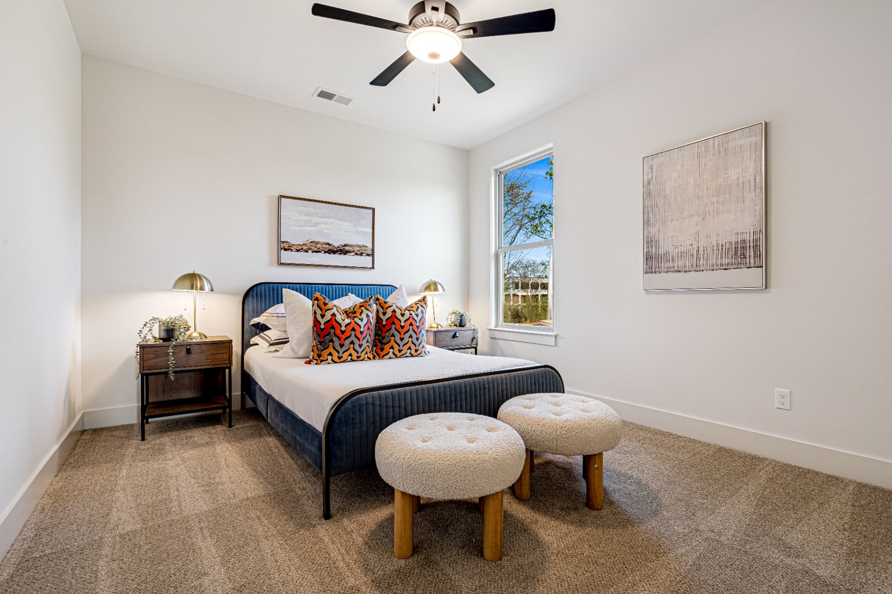 Second bedroom with velvet bed frame and statement pillows